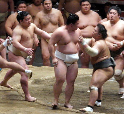 Sumo wrestlers practicing around the training ring
