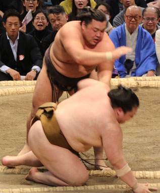 A sumo wrestler sent down to the clay in a bout