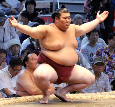 Sumo wrestler Atamifuji crouching at the shikiri line before a bout